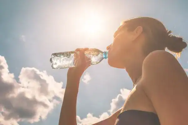 Hydration: The Secret Ingredient for a Toned Stomach and Enhanced Fitness 3 Image of woman drinking water to hydrate Rainham after run.