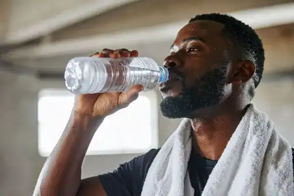Hydration: The Secret Ingredient for a Toned Stomach and Enhanced Fitness 1 Image of man drinking water to improve hydration Rainham after work out.